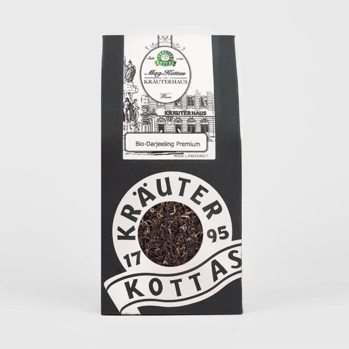 Eine Packung KOTTAS Bio-Darjeeling Schwarztee in elegantem Schwarz-Weiß Design. Der Tee selbst ist dunkel genauso wie die Verpackung, während das Logo weiß strahlt.
