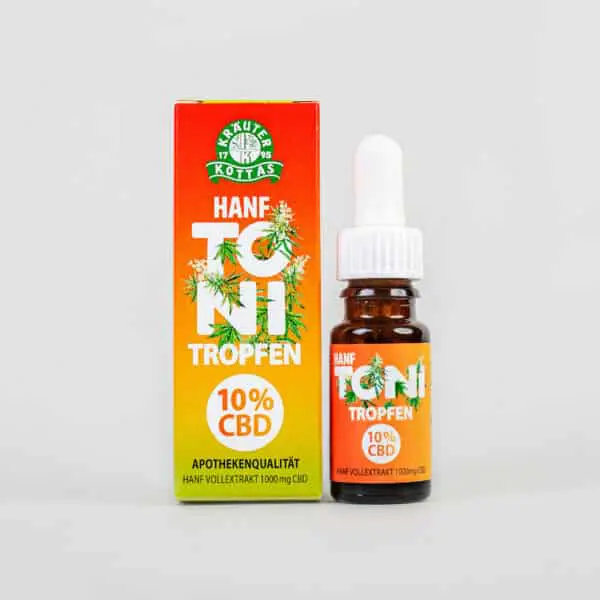 Close-up of a package of Hanf Toni CBD drops in a colourful packaging in Reggae colouring with printed hemp leaves all over. The bottle is dark glass with a plastic dropper.