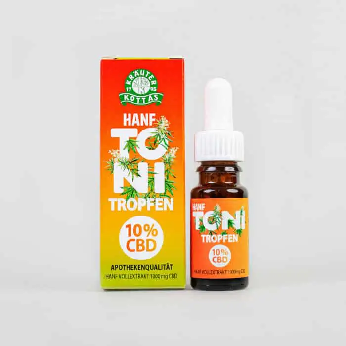 Close-up of a package of Hanf Toni CBD drops in a colourful packaging in Reggae colouring with printed hemp leaves all over. The bottle is dark glass with a plastic dropper.