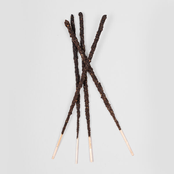 Four Sagrada Madre incense sticks which are rolled by hand and look dark.