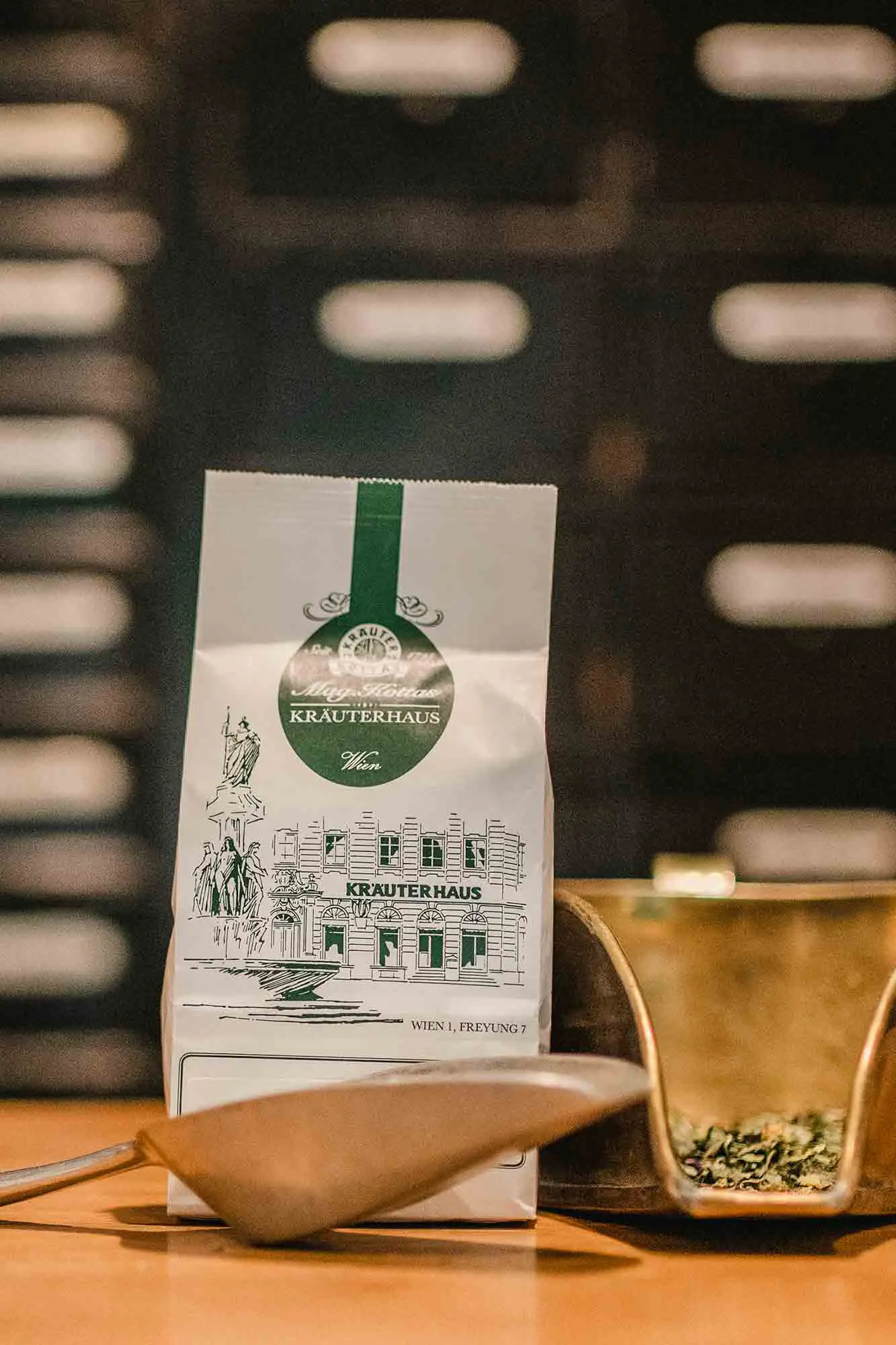 Weiße Teepackung von KOTTAS Kräuterhaus mit zwei Handschaufeln
