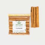Cellophanbeutel mit Ceylon-Zimtstangen, daneben lose liegende Zimtstangen.